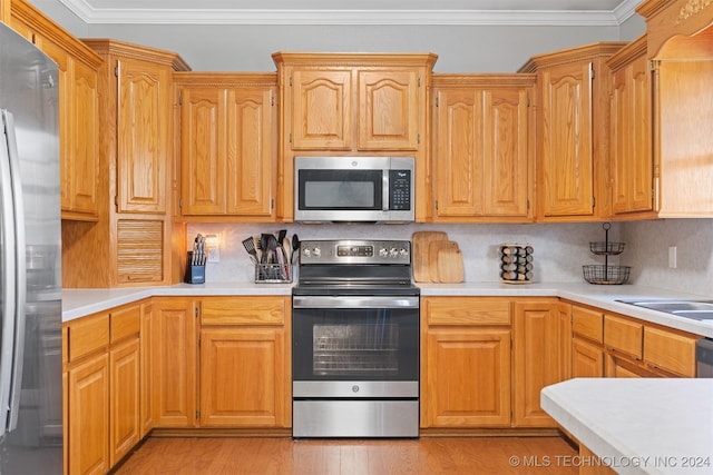 kitchen with decorative backsplash, crown molding, stainless steel appliances, and light hardwood / wood-style flooring