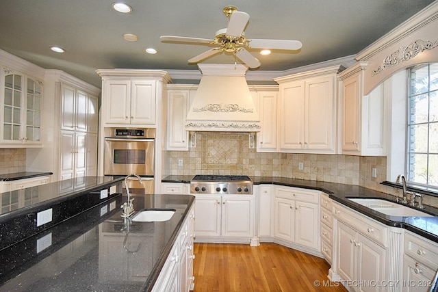 kitchen featuring stainless steel appliances, light hardwood / wood-style flooring, crown molding, and sink