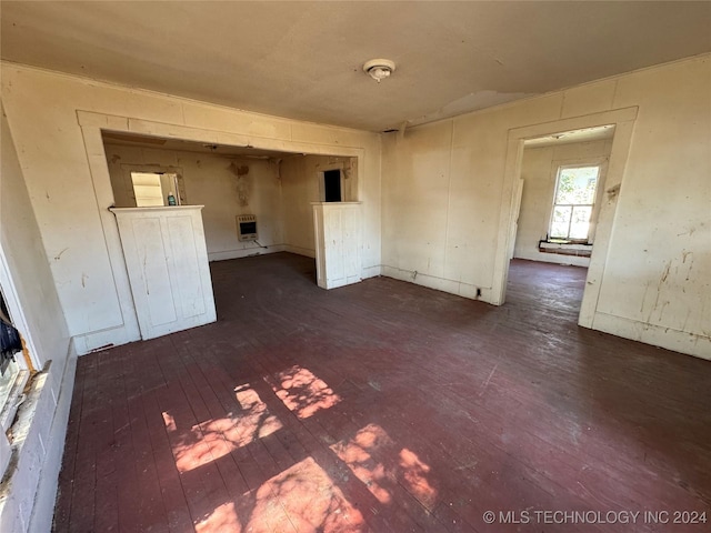 empty room with dark hardwood / wood-style flooring and heating unit