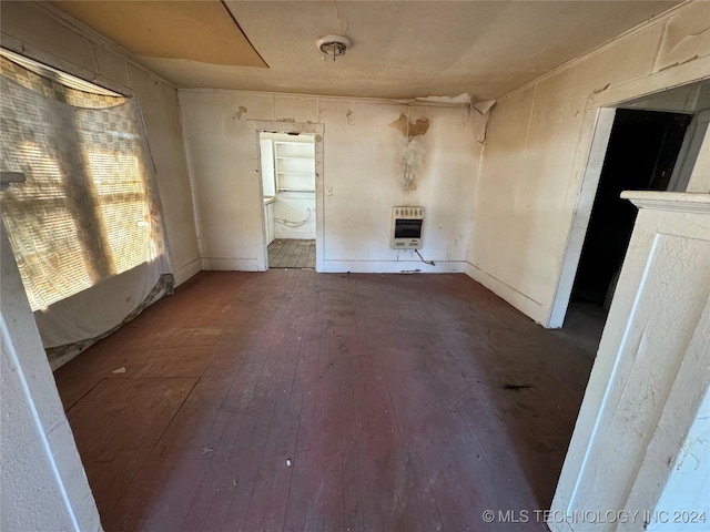 unfurnished living room with dark hardwood / wood-style flooring and heating unit