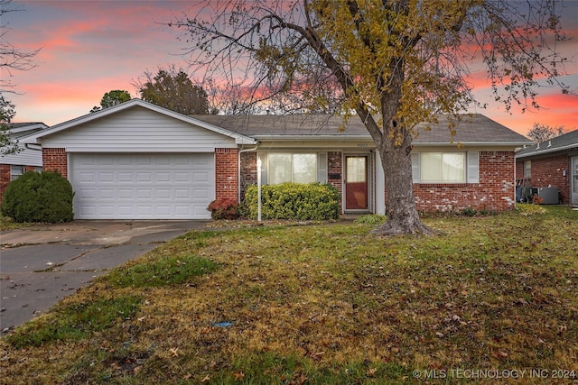 single story home featuring a yard and a garage