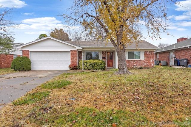 single story home featuring a front lawn and a garage