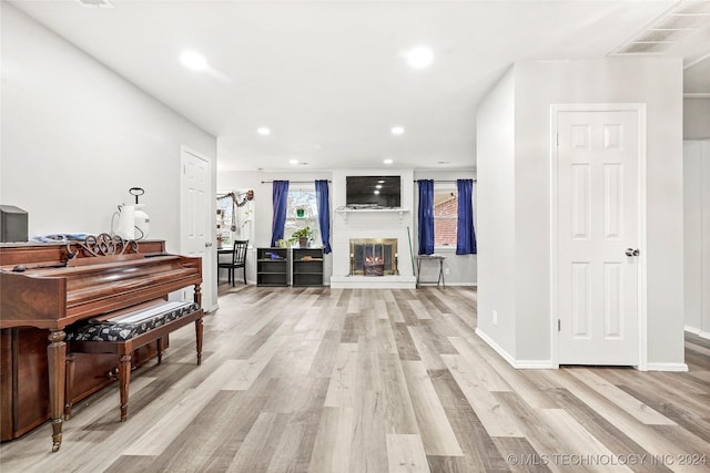 misc room with a fireplace and light hardwood / wood-style floors