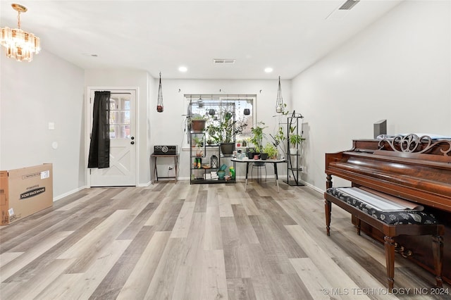 misc room with light hardwood / wood-style flooring and a notable chandelier