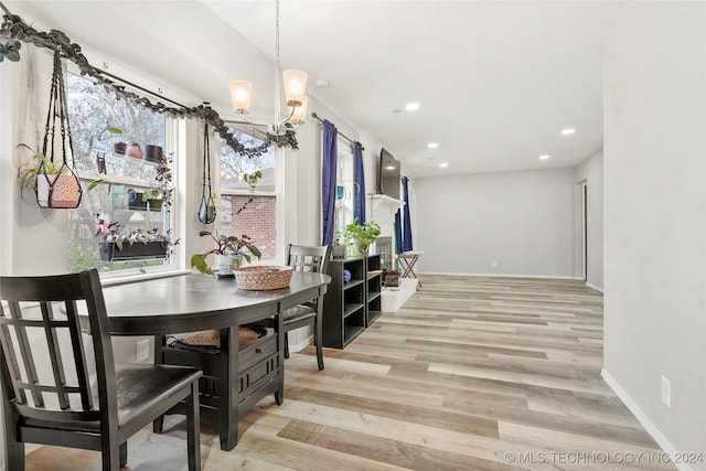 dining space featuring a notable chandelier and light wood-type flooring