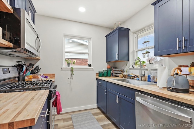 kitchen featuring wood counters, plenty of natural light, and stainless steel appliances