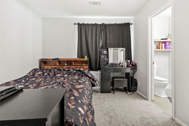 carpeted bedroom featuring ensuite bath