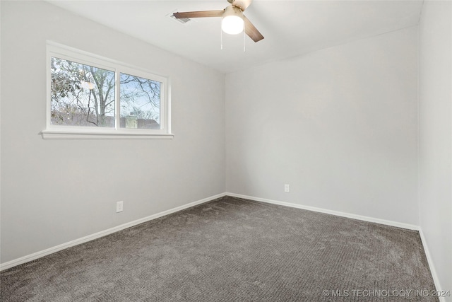 empty room with dark colored carpet and ceiling fan