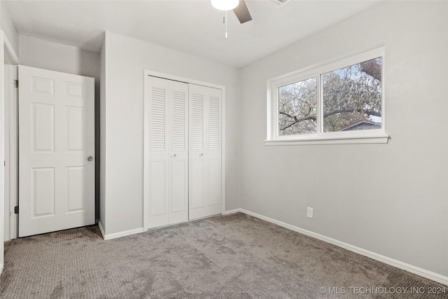 unfurnished bedroom featuring ceiling fan, a closet, and light colored carpet