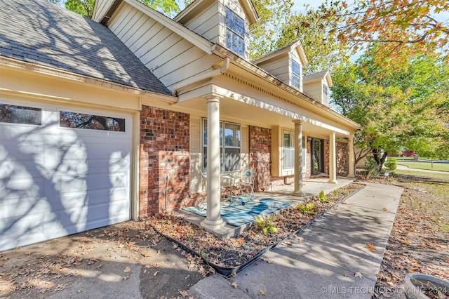 doorway to property featuring a porch and a garage