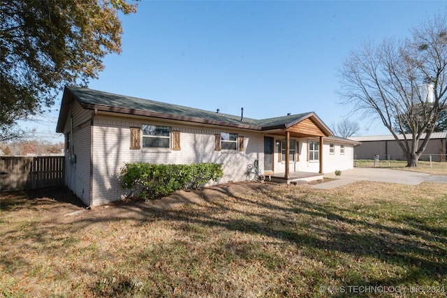 rear view of property featuring a patio area and a yard