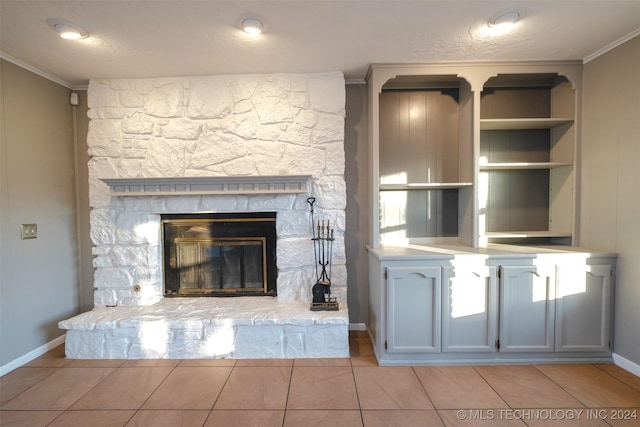 unfurnished living room featuring built in shelves, crown molding, a fireplace, and light tile patterned floors