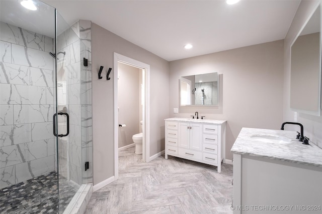 bathroom with vanity, a shower with shower door, and toilet