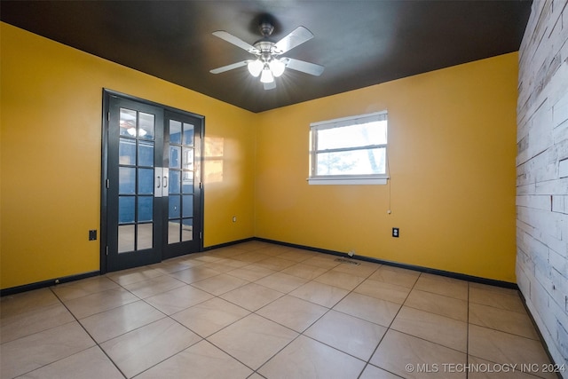 tiled spare room with ceiling fan and french doors