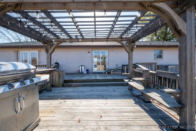 wooden terrace with french doors, a pergola, and a grill