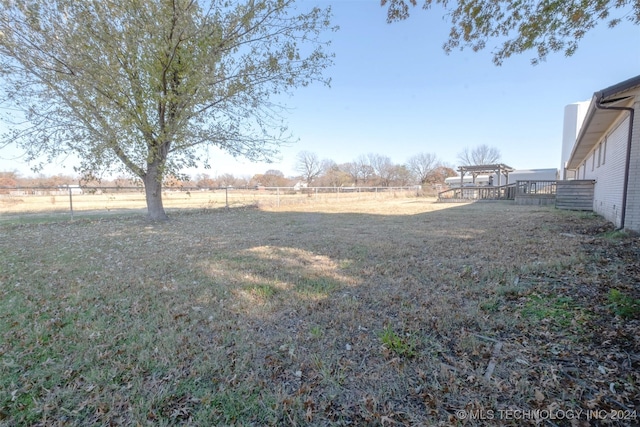 view of yard with a rural view and a wooden deck