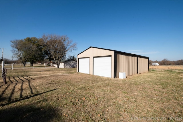 garage featuring a lawn and a rural view