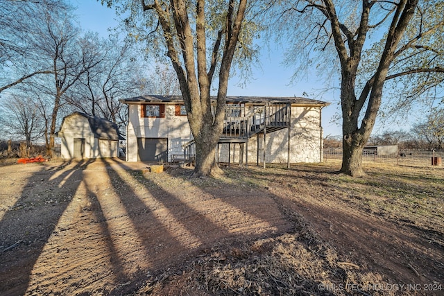 exterior space with a garage, an outdoor structure, and a wooden deck