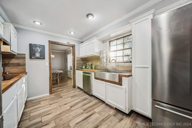 kitchen with backsplash, sink, light hardwood / wood-style flooring, white cabinetry, and stainless steel appliances