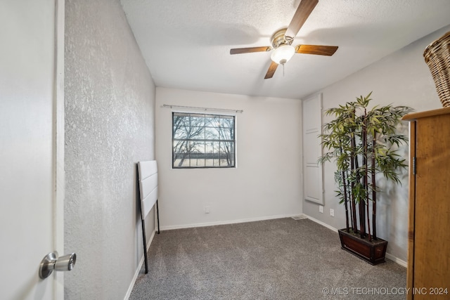 carpeted spare room featuring a textured ceiling and ceiling fan