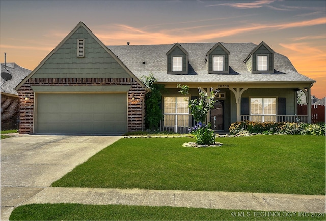 view of front of home featuring a porch, a garage, and a lawn