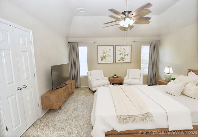 carpeted bedroom with ceiling fan, lofted ceiling, and a closet