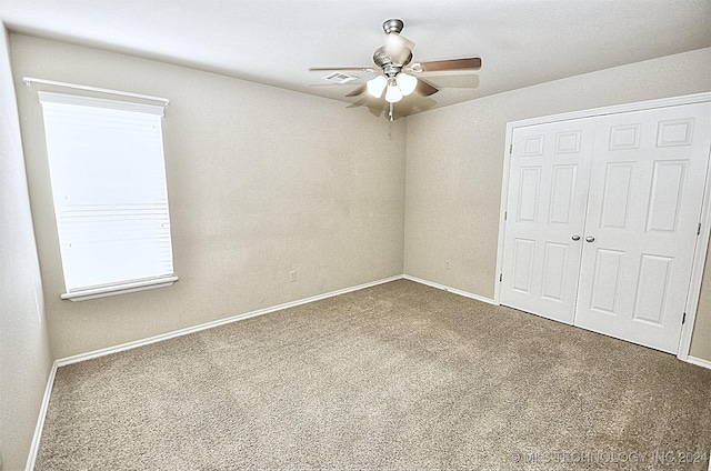 unfurnished bedroom featuring carpet floors, a closet, and ceiling fan