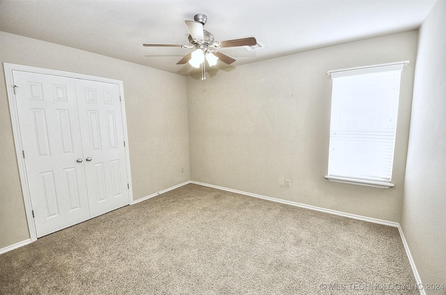 unfurnished bedroom with carpet floors, a closet, and ceiling fan