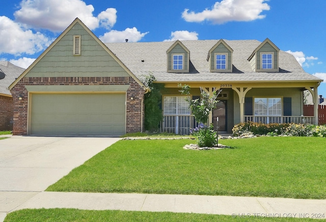 view of front of home with a front yard, a garage, and covered porch