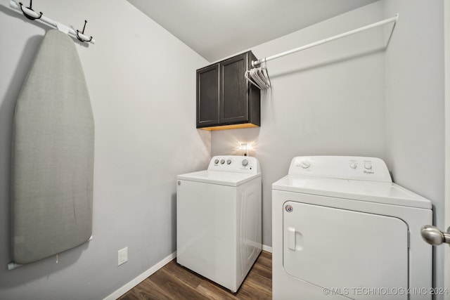 laundry area featuring cabinets, independent washer and dryer, and dark hardwood / wood-style floors