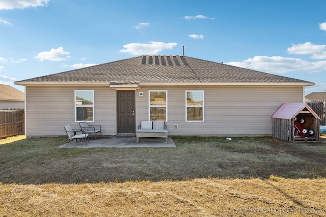 rear view of house with a patio and a yard