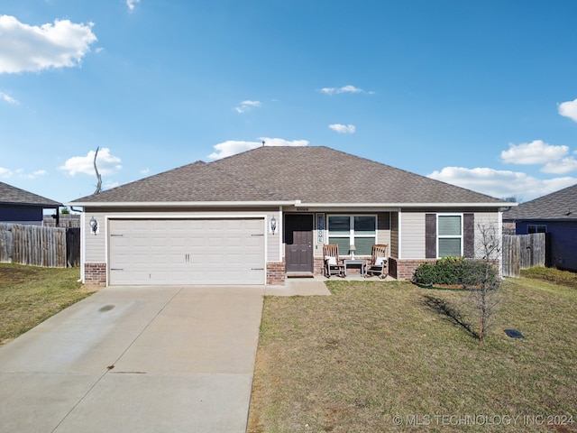 single story home with a garage, a front yard, and a porch