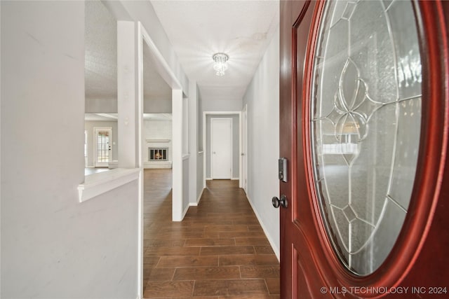 hall featuring a textured ceiling and dark wood-type flooring