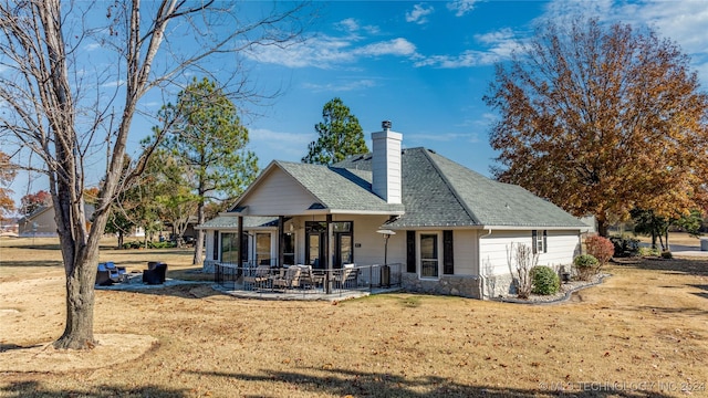 back of house featuring a lawn and a patio area