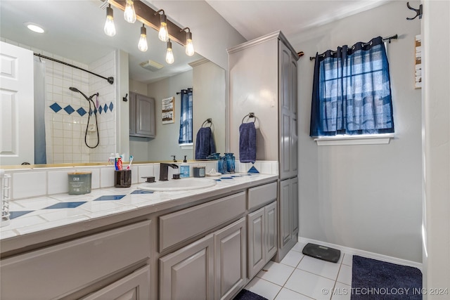 bathroom with tile patterned flooring, vanity, and walk in shower