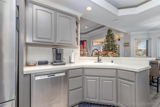 kitchen featuring sink, stainless steel appliances, kitchen peninsula, gray cabinets, and ornamental molding