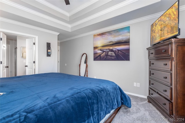 carpeted bedroom featuring ceiling fan, crown molding, connected bathroom, and a tray ceiling