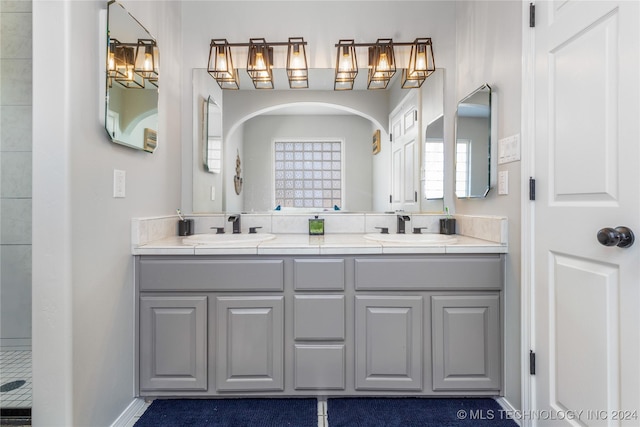 bathroom with a shower, vanity, and a notable chandelier