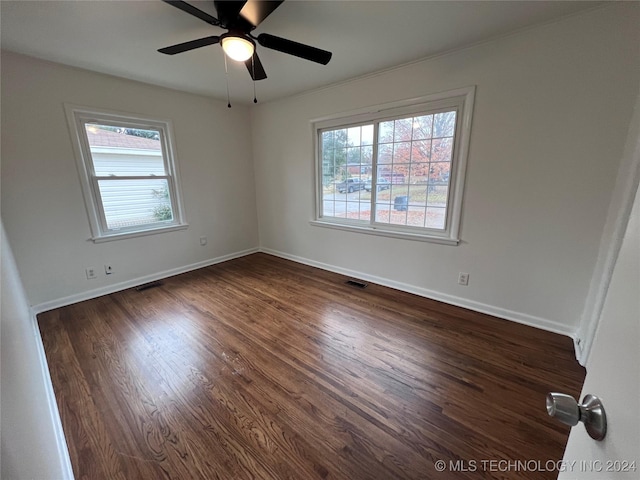 empty room featuring dark hardwood / wood-style flooring and ceiling fan