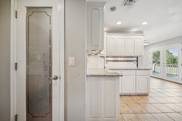 kitchen featuring light stone countertops, french doors, white cabinets, and light tile patterned floors