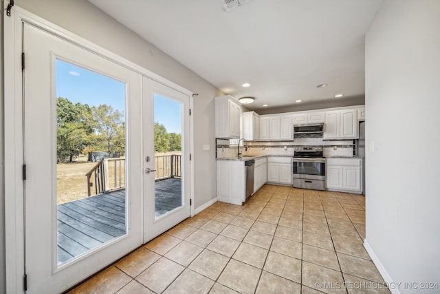 kitchen with appliances with stainless steel finishes, tasteful backsplash, white cabinetry, and french doors