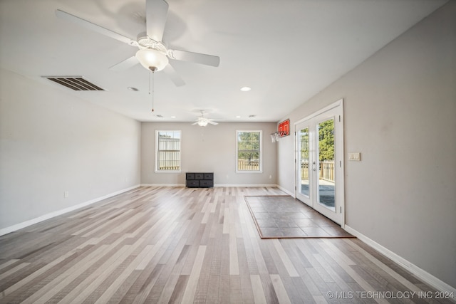 unfurnished living room featuring ceiling fan, french doors, and light wood-type flooring