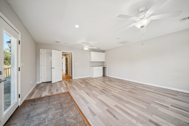 unfurnished living room with ceiling fan and light wood-type flooring