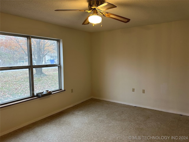 spare room featuring ceiling fan, plenty of natural light, and a textured ceiling