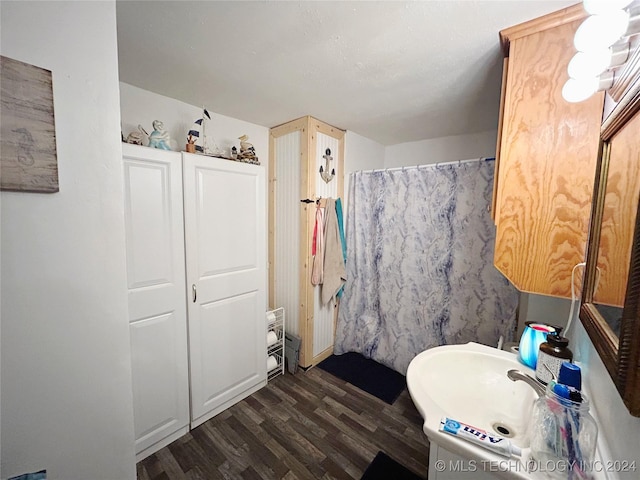 bathroom with curtained shower, sink, and hardwood / wood-style flooring