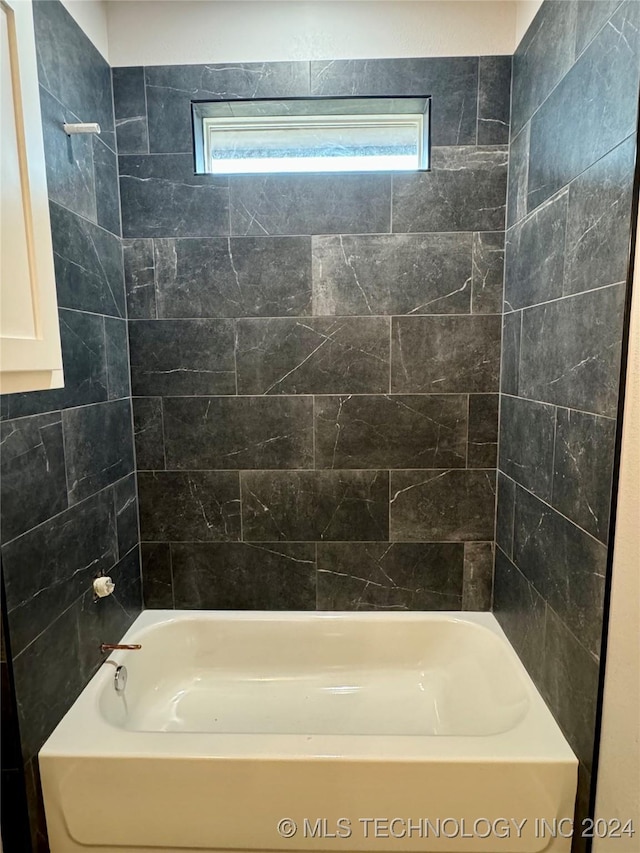 bathroom featuring tiled shower / bath and a wealth of natural light