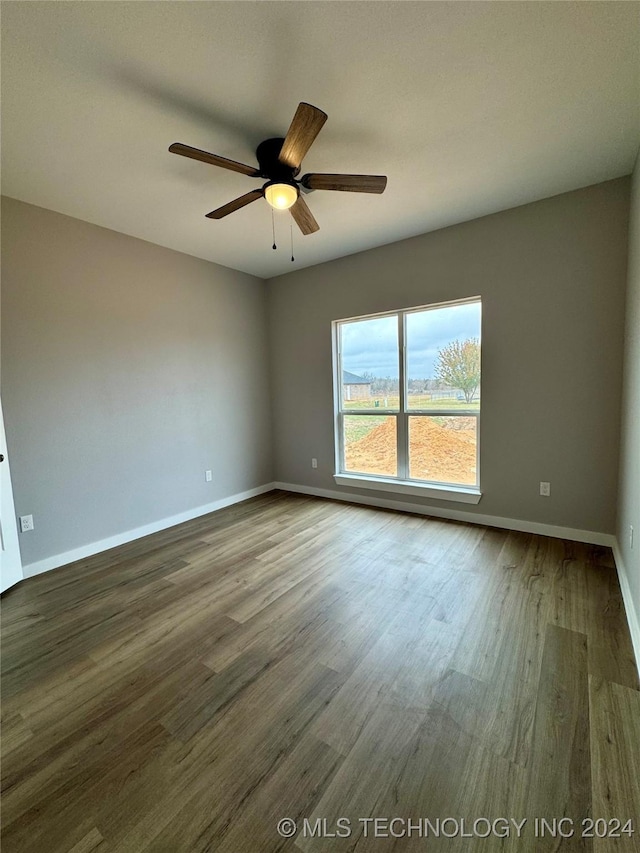 unfurnished room with ceiling fan and dark wood-type flooring