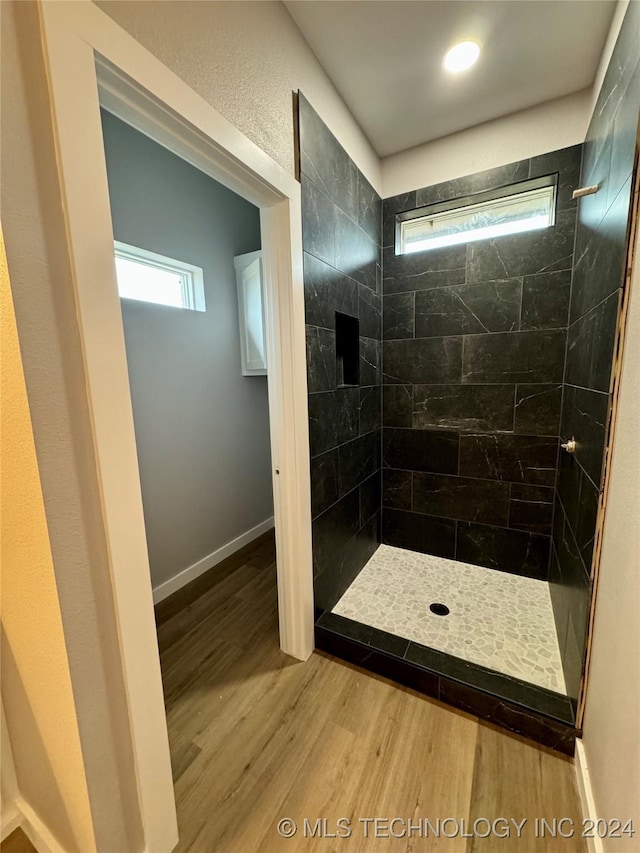 bathroom featuring a tile shower and hardwood / wood-style flooring