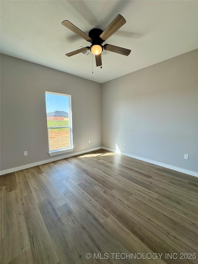 unfurnished room with wood finished floors, baseboards, and ceiling fan