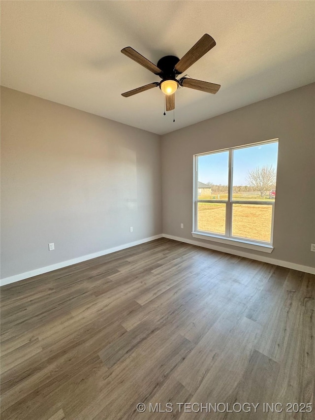 spare room featuring baseboards, a ceiling fan, and wood finished floors